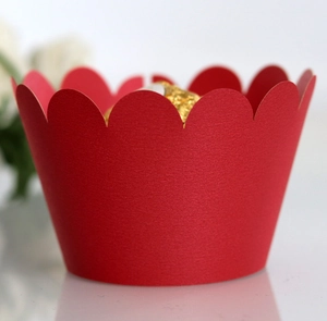 Macro shot of red laser-cut cupcake wrappers with wavy edges for festive desserts
