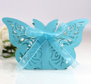 Detailed laser-cut blue wedding favor box with butterfly top and light blue ribbon