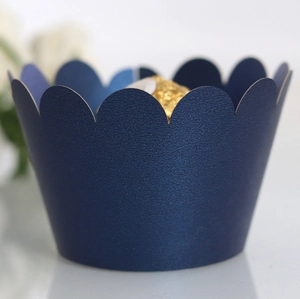 Close-up of dark blue pearlescent paper cupcake wrapper with elegant scalloped edges