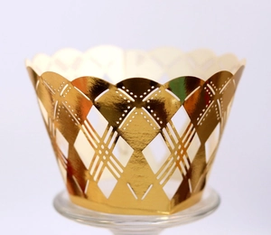 Detail of laser-cut gold hollow cupcake wrapper with geometric patterns and wavy edge