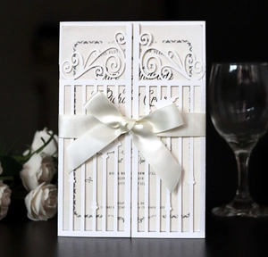 Détail de l'invitation de mariage découpée au laser avec nœud satin et papier perlé