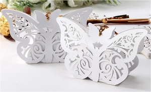 Detail of white laser-cut butterfly candy box with pearlescent paper and gold ribbon
