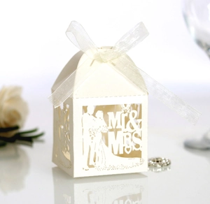 Detail of laser-cut white favor box with Mr & Mrs silhouette and elegant white ribbon