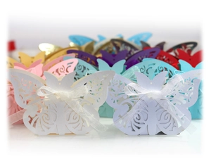 Detailed laser-cut butterfly wedding favor boxes with elegant silk ribbons in multiple colors