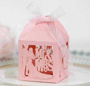 Detail of laser-cut pink wedding favor box with Mr & Mrs silhouette and silk ribbon bow