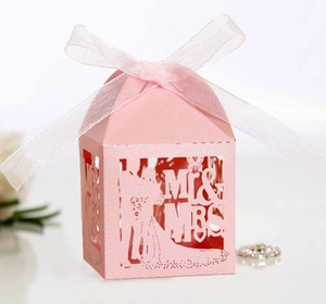 Detail of pink laser-cut wedding favor box with Mr & Mrs silhouette and sheer ribbon