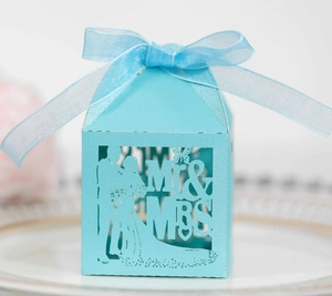 Detail of light blue laser-cut wedding favor box with Mr & Mrs silhouette and organza ribbon