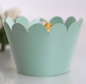 Macro shot of mint green pearlescent cupcake wrappers with elegant scalloped edges