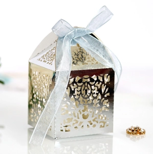Detailed laser-cut pattern on silver wedding favor box with a light blue silk ribbon