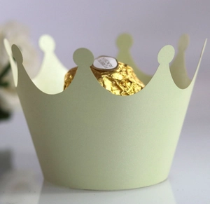 Macro shot of crown-shaped light green paper cupcake wrappers for dessert decoration