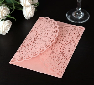 Detail of pink laser-cut lace wedding invitation cover in premium pearlescent paper