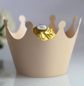 Close-up of beige crown-shaped paper chocolate holder for elegant party dessert decor