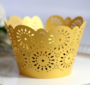 Detail of golden laser-cut cupcake wrappers with intricate floral hollow patterns