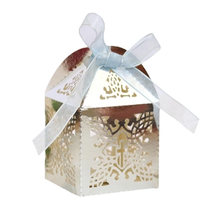 Detail of laser-cut cross hollow candy box in gold finish with a light blue ribbon