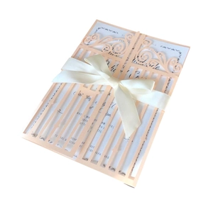 Détail de l'invitation de mariage découpée au laser avec un ruban de satin élégant