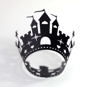 Macro detail of laser-cut black castle fortress cupcake wrapper with star and heart cutouts
