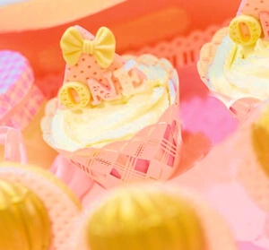 Macro detail of laser-cut cupcake wrappers and 'ONE' topper for 1st birthday party decor