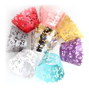 Laser-cut cupcake wrappers with intricate floral vine patterns in multiple colors