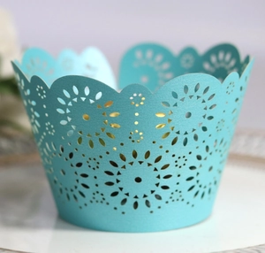 Close-up of laser-cut light blue cupcake wrapper with pearlescent finish and hollow pattern