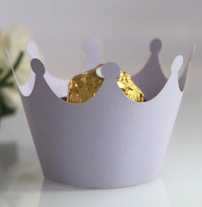 Detail of light purple crown-shaped paper cupcake wrapper with hollow design