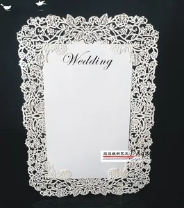 Detail eines lasergeschnittenen Spitzenmusters auf weißer Hochzeitseinladung mit Text