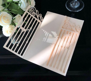 Détail de l'invitation découpée au laser sur papier nacré crème avec motif de porte festif