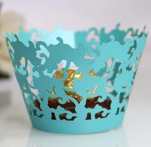 Intricate laser-cut light blue cupcake wrapper with floral pattern and chocolate detail