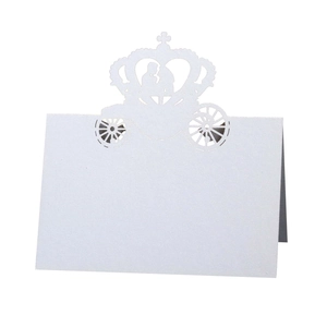 Laser-cut white wedding table card with a crown and pumpkin carriage silhouette