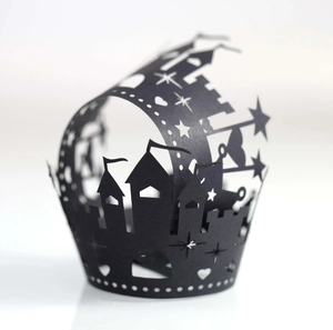 Macro detail of laser-cut black Halloween cupcake wrappers featuring castle and star designs