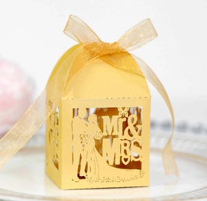 Detail of laser-cut Mr & Mrs wedding candy box with golden silk ribbon bow