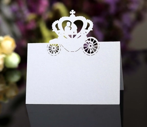Detail of laser-cut white carriage wedding place card with pearlescent finish