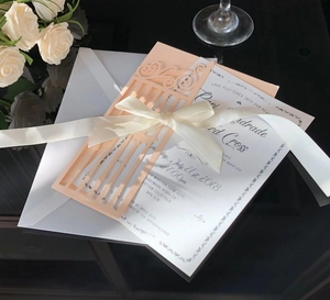 Détail de l'invitation de mariage découpée au laser avec ruban et motif floral