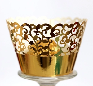 Elegant gold laser-cut lace cupcake wrappers with intricate floral vine patterns for party