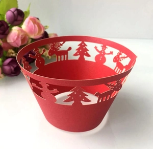 Detail of red laser cut cupcake wrappers with Christmas snowman and reindeer patterns