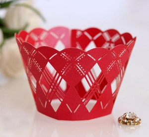 Detail of red laser-cut cupcake wrappers with geometric diamond pattern and wavy edges