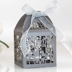 Détail d'une boîte de mariage grise découpée au laser avec motif floral et ruban en soie