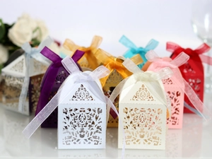 Macro view of laser-cut wedding favor boxes with elegant ribbons in various colors