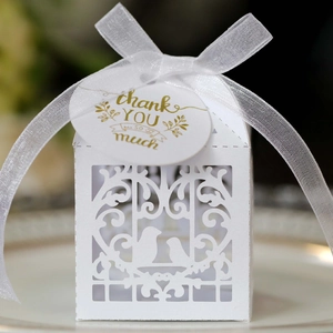 Détail de boîte à dragées blanche découpée au laser avec motif oiseau et étiquette