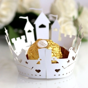Macro detail of laser-cut white castle pattern paper wrapper for cupcakes and chocolates