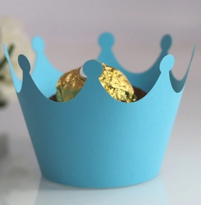 Sky blue crown cupcake wrapper with intricate cutout detail and chocolate inside