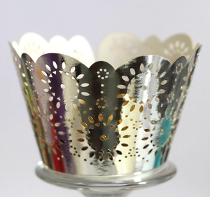 Macro detail of laser-cut silver cupcake wrapper with elegant floral hollow patterns