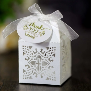 Elegant white laser-cut wedding favor box with cross design and silver ribbon