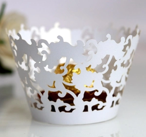 Elegant white laser-cut cupcake wrappers with floral vine lace pattern for wedding decor