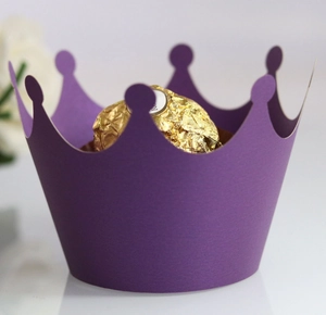 Detail of purple laser-cut crown cupcake wrapper with golden chocolate inside