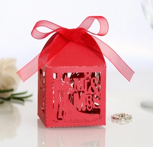 Detail of red laser-cut favor box with Mr & Mrs silhouette and decorative silk ribbon