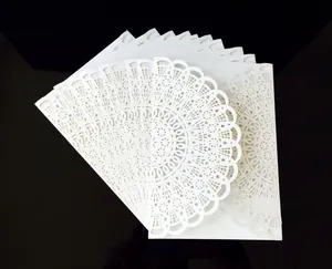 Macro detail of white laser-cut wedding invitation with intricate mandala floral patterns
