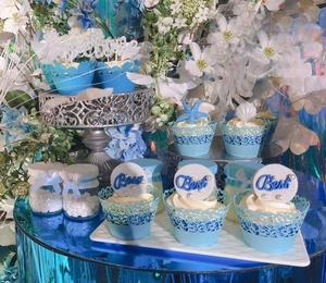 Laser cut lace cupcake wrappers set with sea shell toppers for wedding dessert tables