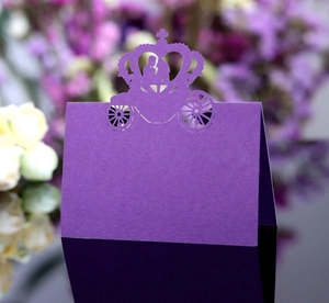Detail of purple laser-cut wedding table card featuring a royal carriage and crown design