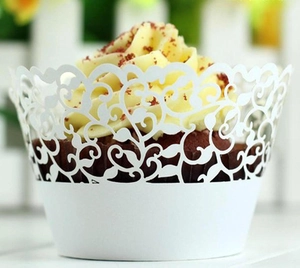 Macro detail of white laser-cut lace cupcake wrapper with elegant filigree pattern