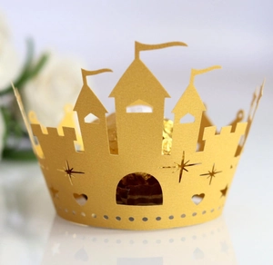 Close-up of golden laser-cut castle cupcake wrappers with star and heart hollow details